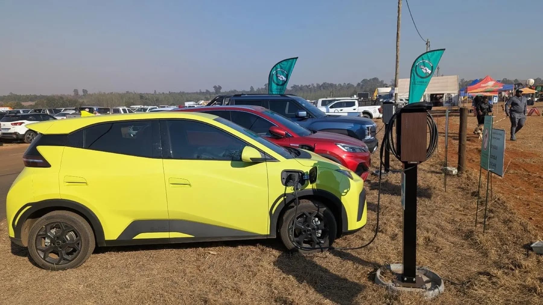 An electric hatchback plugged into a Conduit charge post at KragDag 2026, with more EVs queued behind it
