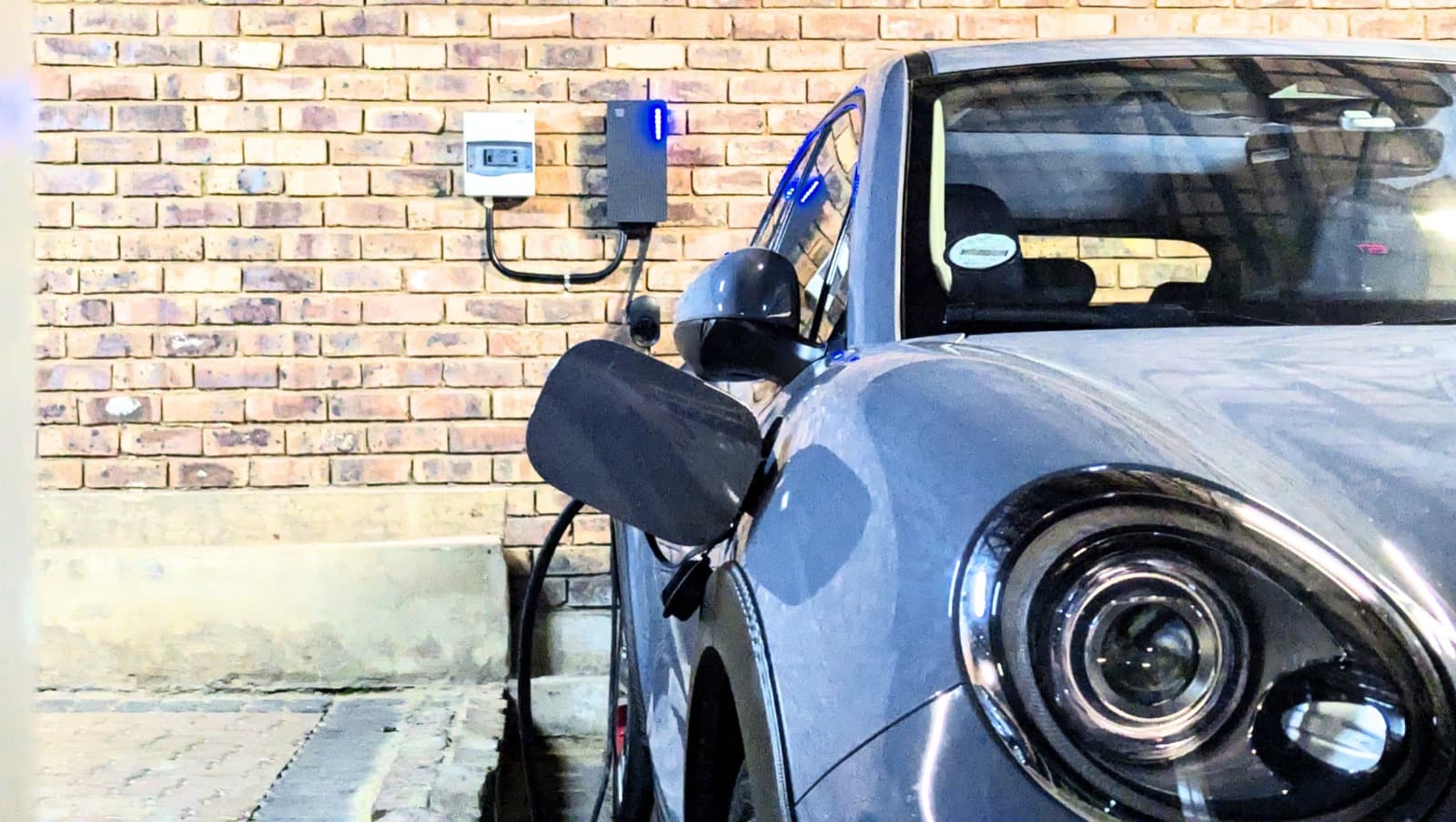 Mini charging from a TeltoCharge mounted on a face-brick wall
